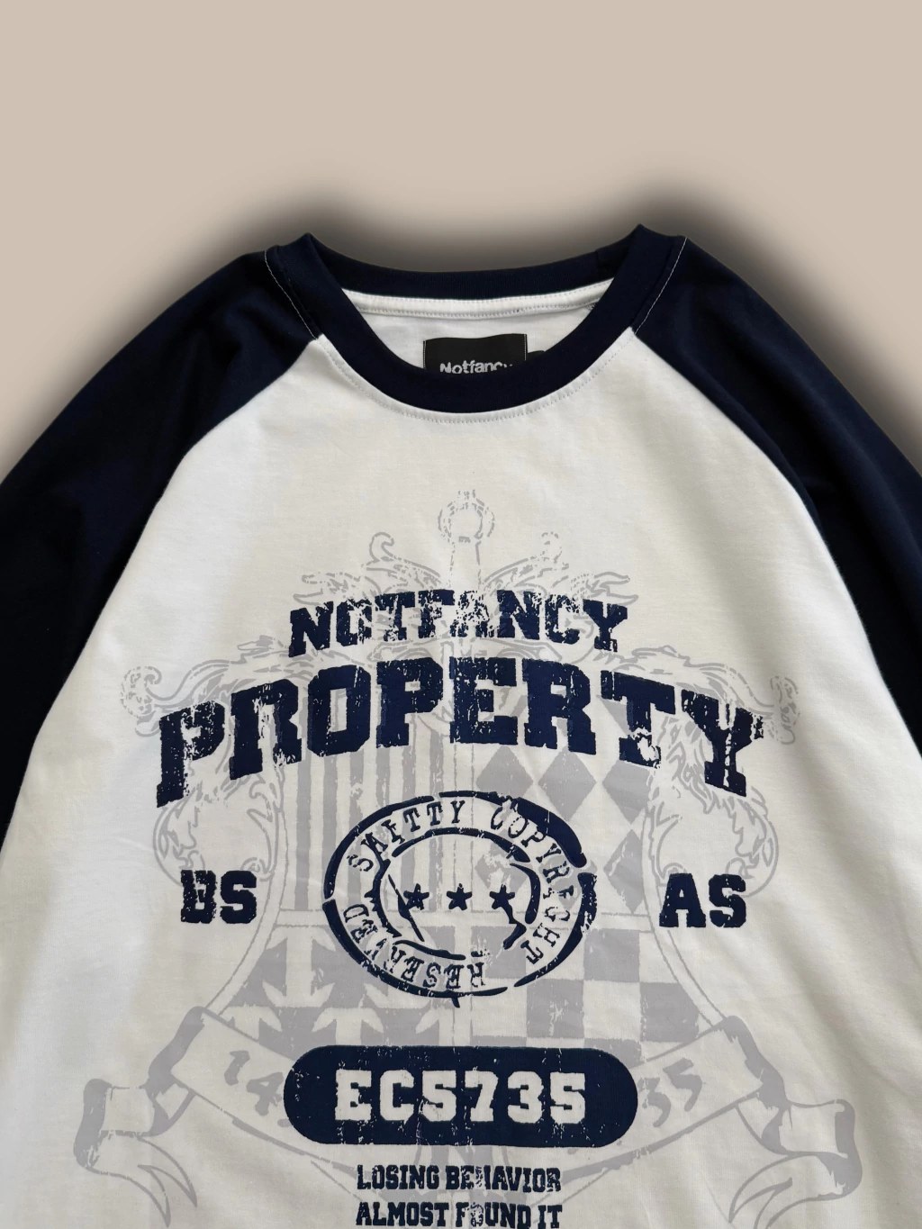 Detalle de la remera azul marino y blanca con la gráfica Notfancy Property