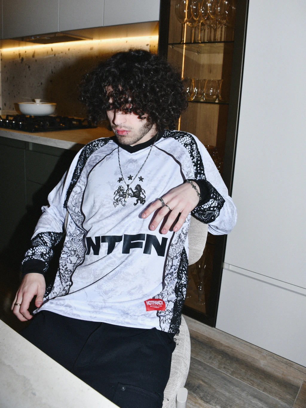 Modelo sentado en una cocina con la camiseta Team Notfancy